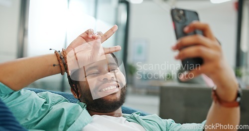 Image of Black man, phone and peace sign on video call with smile for social, networking or communication at the office. African American man relaxing on break talking on smartphone videocall at the workplace