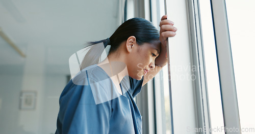 Image of Mental health, stress and depressed doctor at window in China, burnout and headache from late surgery. Anxiety, depression and woman in medical field or healthcare professional overworked and tired.