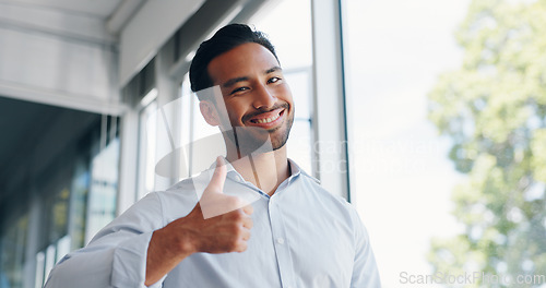 Image of Businessman, thumbs up and wink while walking in office for success, motivation or thank you. Face portrait, yes and male employee from Singapore with hand gesture for support, like emoji or approval