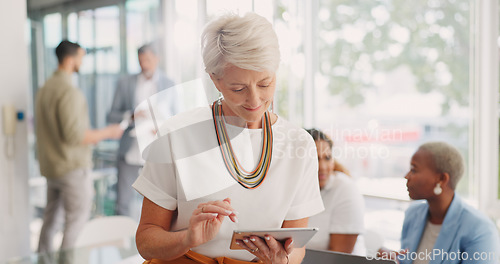 Image of Business woman, senior and digital tablet for leader planning, thinking and research while in business meeting. Mature woman, internet and search while leading a meeting with creative group in office