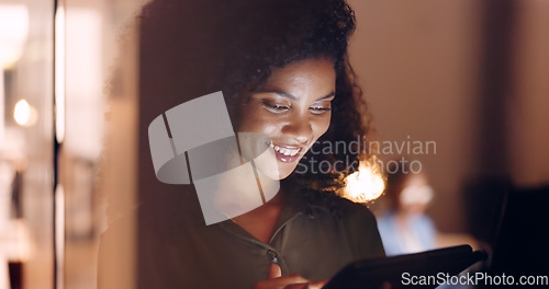 Image of Office, night and happy black woman on a phone at her job in the dark smiling about funny text. Business, technology and social media mobile app scroll of a person working late on a work break