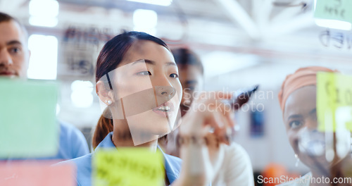 Image of Creative business people, planning and sticky note for brainstorming, ideas or project at the office. Group of employee designers in post it, schedule and meeting plan on glass for corporate startup