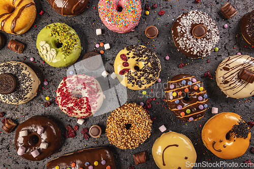 Image of Various glazed doughnuts with sprinkles.