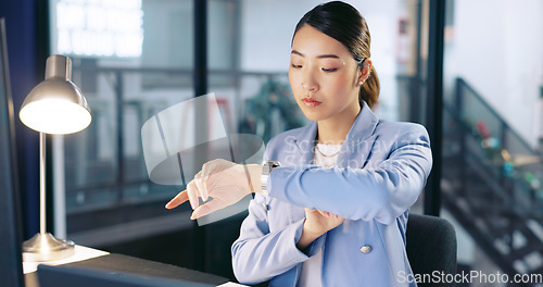 Image of Night, watch and late with a business asian woman at work for overtime on a deadline in her office. Computer, target and report with a female employee working on a desktop alone in the workplace