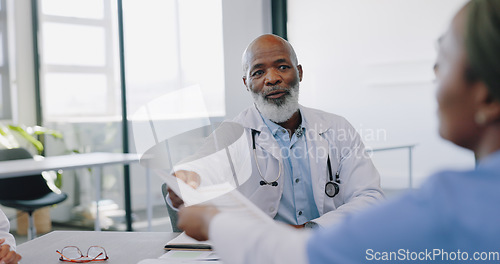 Image of Meeting, healthcare and collaboration with a doctor black man and his medicine team in discussion over documents at the hospital. Nurse, teamwork and partnership with professional medical group