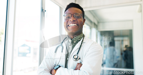 Image of Portrait, healthcare and trust with a black man doctor standing arms crossed in a hospital hallway. Health, medical and insurance with a male medicine professional working in a clinic for treatment