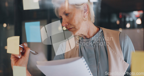 Image of Planning, CEO or woman writing on sticky note for development project or brainstorming creative ideas. Focus, data analysis or company manager working on marketing goals or branding strategy at night