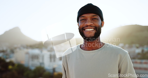 Image of Face, happy and street style with a black man outdoor in the city with nature in the background during summer. Portrait, fashion and urban with a handsome young male standing outside in a bright town