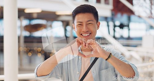 Image of Shopping, hands in heart and face of Asian man with smile for shopping, retail and consumerism. Lifestyle, commerce and male enjoying weekend at shopping mall in Tokyo for sale, discount and bargain