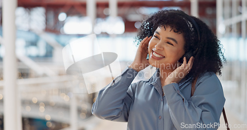 Image of Music, headphones and black woman in mall for freedom, relax and calm energy, dance, listening and happy with her travel journey. Urban building, gen z and audio technology for inspiration in retail