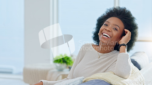 Image of Portrait of a happy afro woman relaxing at home on the weekend. Beautiful casual African American female smiling and enjoying a relaxed Sunday afternoon in her bright living room with copy space