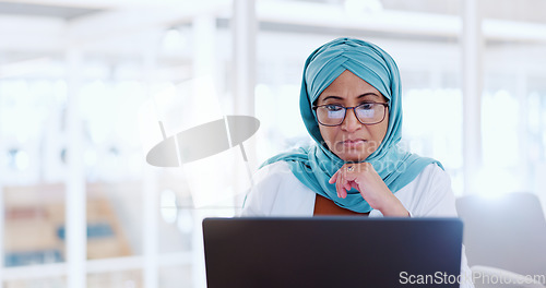 Image of Muslim business woman, focus and working at laptop, email and communication with focus and technology. Worker in hijab, corporate goals with internet, networking and research online for project