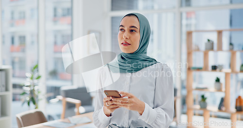 Image of Phone, thinking and feedback with a business muslim woman typing a text message in her office at work. Contact, mobile and idea with an islamic female employee reading an email while working alone