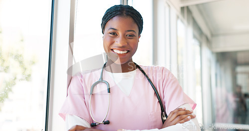 Image of Portrait, healthcare and hospital with a nurse black woman arms crossed in a hallway with a stethoscope. Medical, insurance and service with a female medicine professional standing in a clinic