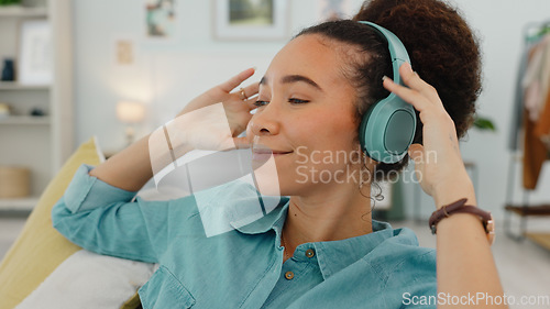 Image of Relax, music and black woman with headphones on sofa for wellness rest and streaming with satisfied smile. Self care, happy and comfortable girl listening to musical audio app in home bedroom.