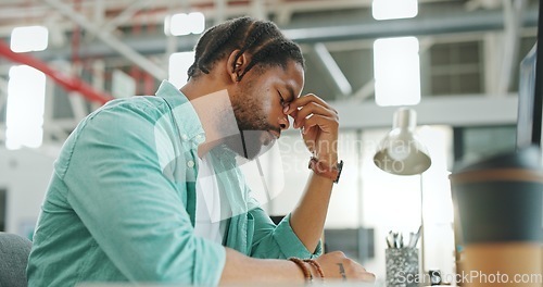 Image of Headache, tired and burnout business man, working on laptop in office with stress, anxiety and burnout. Fatigue, depression and mental health risk of black man employee headache, angry or frustrated