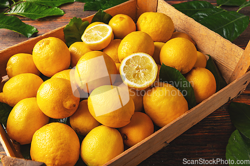 Image of Fresh lemon with leaves in crate