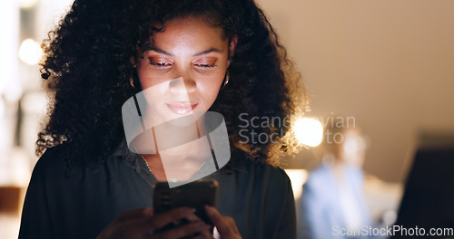 Image of Social media, phone and black woman in a dark office for a corporate deadline at night. African worker, manager or employee typing on a mobile app with a smartphone while working overtime at work