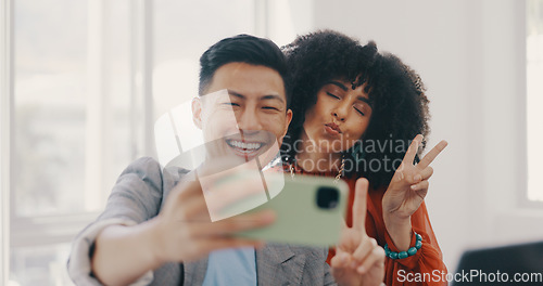 Image of Phone, selfie and business people with peace in office for teamwork, collaboration and friendly workspace. Success, diversity and Asian man and black woman with smartphone, peace sign and smile