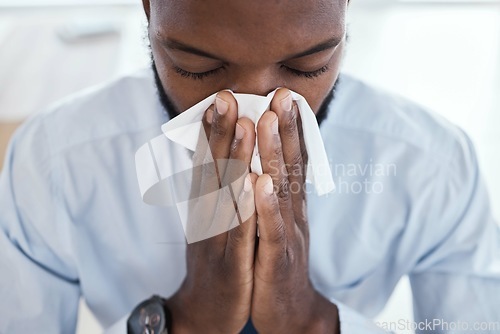 Image of Black man, tissue and blowing nose in the office with allergies, sickness and virus. Business employee, face and corporate worker sick with a cold or allergy sneeze in the workplace with fever