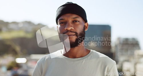 Image of Face, confident and city with an edgy black man outdoor in an urban town for fashion or street style. Portrait, cityscape and lifestyle with a young African American male outside on a summer day