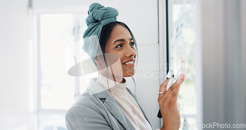 Image of Business woman, writing and brainstorming idea with glass board and post it, happy with focus and planning strategy for project. Corporate employee, marketing strategy or project management goals.