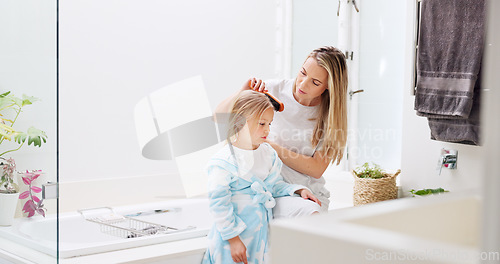 Image of Morning, mother and daughter in bathroom with hair brush for grooming care routine in family home. Motherhood, child and mama brushing hair of young kid in house and getting ready for the day.