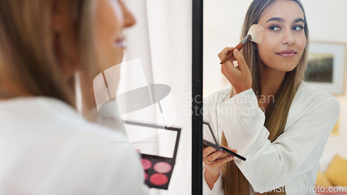 Image of Makeup, wedding and bride with a woman using cosmetics on her face before a marriage ceremony or celebration event. Beauty, tradition and smile with a happy female putting blusher on her skin