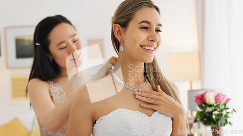 Image of Wedding, friends and bride with necklace jewelry for beauty, wealth and luxury with happiness and fashion lifestyle. Happy women and bridesmaid in dressing room helping with silver diamond chain