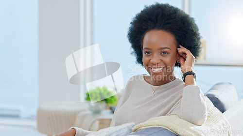 Image of Portrait of a happy afro woman relaxing at home on the weekend. Beautiful casual African American female smiling and enjoying a relaxed Sunday afternoon in her bright living room with copy space