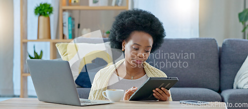 Image of Women with coffee, sitting on the floor, back against the sofa reading email, checking social media at home. Woman working from home with computer and tablet in living room on internet.