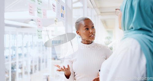 Image of Teamwork, business people and leadership of black woman with sticky note in office workplace. Coaching, collaboration and female employees brainstorming sales or marketing strategy on glass wall.