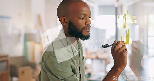 Image of Sticky notes, meeting and businessman writing idea, vision and brainstorming in office. Black man with post it notes on glass wall for presentation in business meeting, thinking and working on ideas