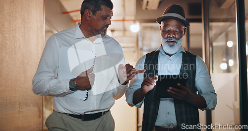 Image of Partnership, tablet and businessmen walking in the office analyzing, talking and planning a project. Technology, professional and senior male employees working on a mobile device in the workplace.