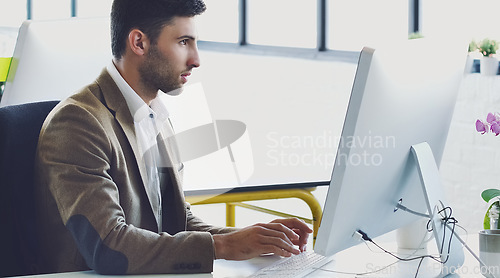 Image of Research, planning and serious with businessman at computer for designer, idea and email. Technology, internet and creative with person typing in digital agency startup for data, vision and focus