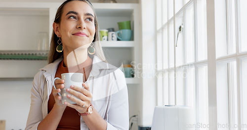 Image of Beautiful woman looking out window holding cup of coffee