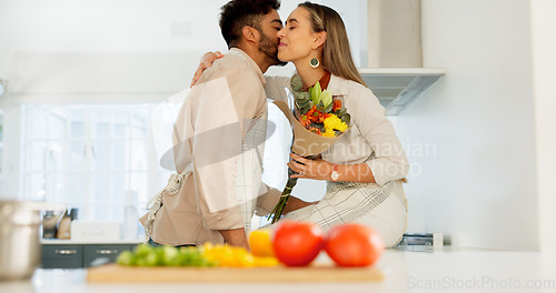 Image of Couple love, flowers and happy cooking together in kitchen at home, romance and celebrate relationship bonding. Married man and woman smile, surprise bouquet and happiness care in family house