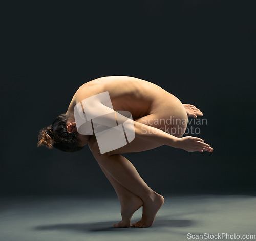 Image of Body, nude and ballet with a model woman in studio on a dark background for dance or performance arts. Creative, skin and beauty with a female ballerina posing nude on black for artistic freedom