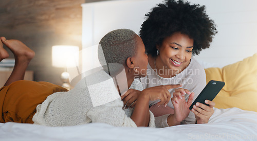 Image of Women, phone and laughing in house bedroom, home interior or relax hotel with social media technology for dating app profile search. Smile, happy and comic friends with mobile for fun communication