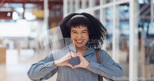 Image of Hands, heart and love with a business black woman making a hand gesture alone in her office at work. Happy, smile and positive with a female employee gesturing a hand sign for romance or affection