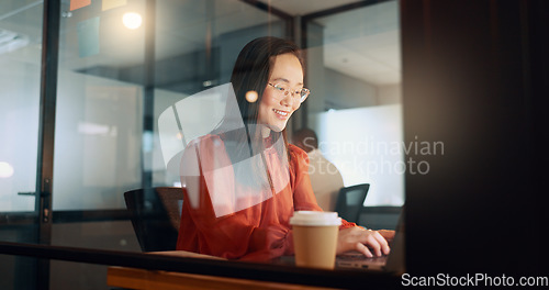 Image of Laptop, night office and Asian woman typing email, sales proposal or finishing project deadline. Computer, tech and happy female employee working late in dark workplace, researching or writing report