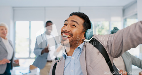 Image of Music, dance and motivation with a business man walking in an office while feeling positive or carefree. Success, happy or smile with a happy male employee arriving at work in headphones with a smile