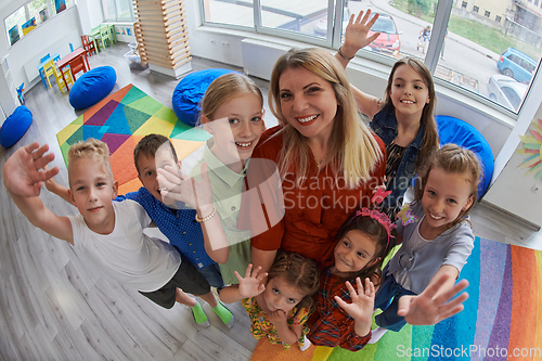 Image of Children in a preschool institution standing in the classroom together with the teacher