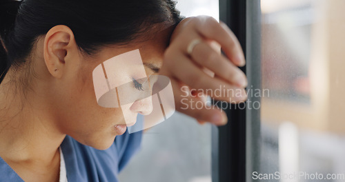 Image of Doctor woman, burnout and anxiety in hospital, workplace and tired in healthcare job, stress or headache. Nurse, sad and exhausted in medical service, clinic or depression in health career by window