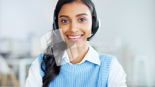 Image of Portrait of a call center agent using a headset while consulting for customer service and sales support. Confident young businesswoman smiling while operating a helpdesk and looking confident