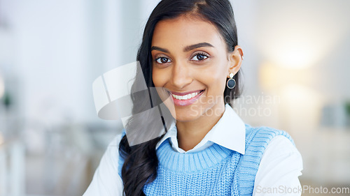 Image of Confident and happy indian business woman feeling ambitious and motivated for success in a creative startup agency. Portrait of a young designer smiling while working on a laptop in a modern office.