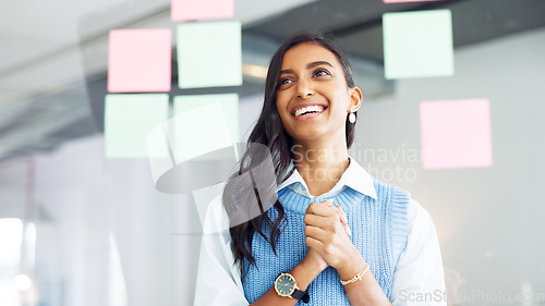 Image of Focused young business woman thinking while brainstorming solutions for a project and marketing strategy in a creative startup agency. Designer planning ideas and information on a window in an office