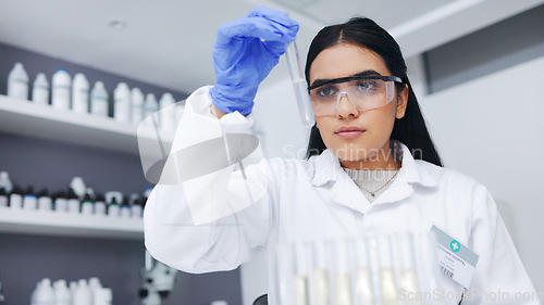 Image of Young female scientists doing tube testing in a modern laboratory. Micro biologist examine liquid bacteria in glassware mixture to invent a vaccine cure for virus at innovative research hospital