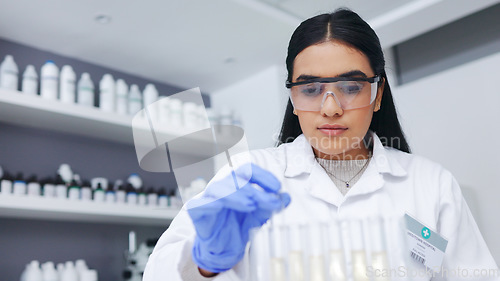 Image of Young female scientists doing tube testing in a modern laboratory. Micro biologist examine liquid bacteria in glassware mixture to invent a vaccine cure for virus at innovative research hospital
