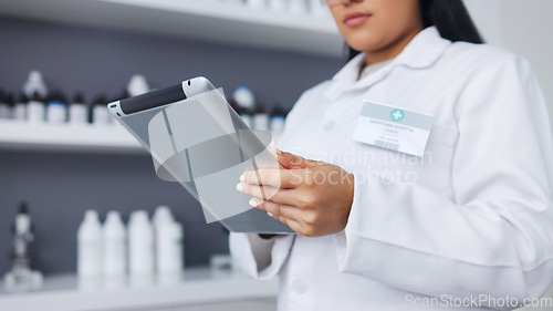 Image of Young scientist using a digital tablet and microscope in a lab. Female pathologist analyzing medical samples while doing experiments to develop a cure. Microbiologist conducting forensic research